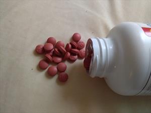 Photo of a bottle of ibuprofen on its side with pillls spilling out. 